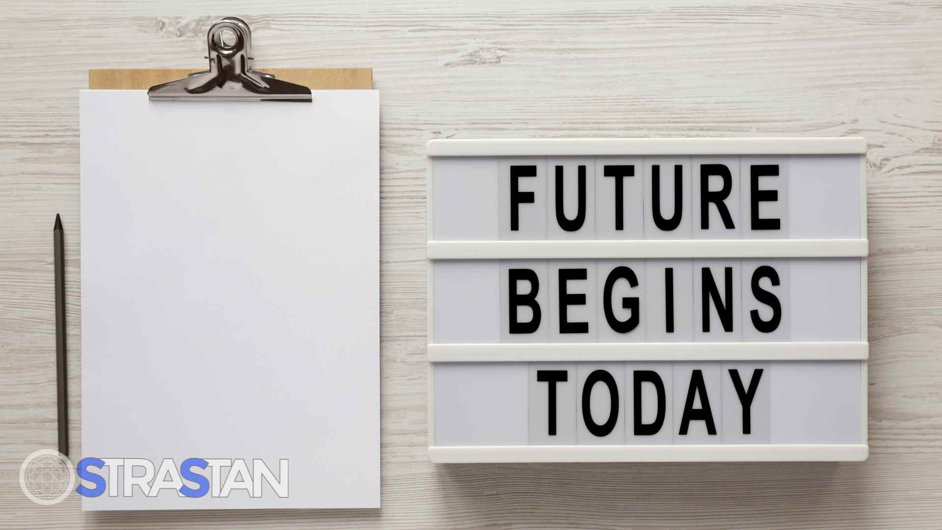  A lightbox sign reading 'Future Begins Today' next to a blank clipboard, symbolizing the proactive planning needed when thinking a decade forward.